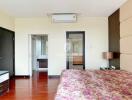 Bedroom with floral bedspread and view of adjoining bathroom