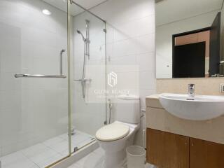 Modern bathroom with glass shower, toilet, and sink