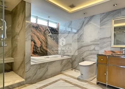 Modern bathroom with marble finishing, a bathtub, shower, and vanity