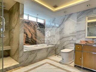 Modern bathroom with marble finishing, a bathtub, shower, and vanity