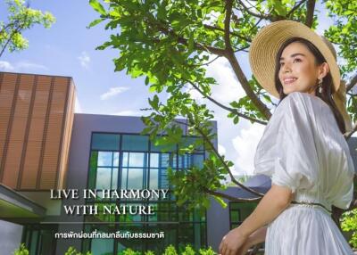 Woman in front of modern house surrounded by nature