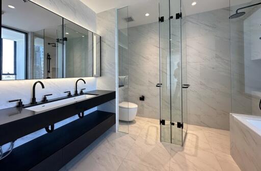 Modern bathroom with double sinks and glass shower enclosure