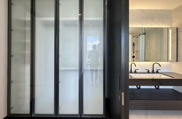 Modern bathroom with double sink and frosted glass shower