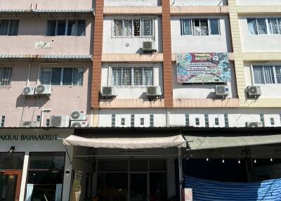 Front view of a building with retail spaces and apartments above