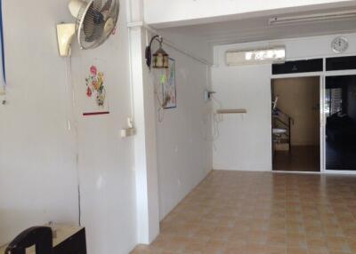 Living room with tiled floor, wall fan, and decorative wall art