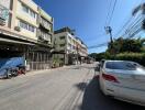 Street view with multiple buildings and parked cars