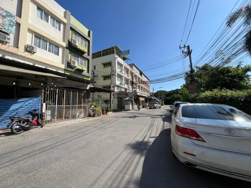 Street view with multiple buildings and parked cars