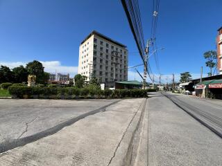 Street view of an apartment building with greenery