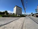 Street view of an apartment building with greenery