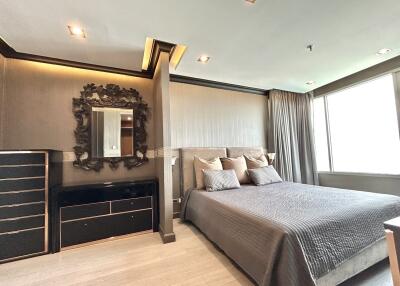 Modern bedroom with large window, bed, nightstand, and decorative mirror