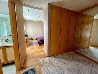 A bedroom with an en-suite bathroom and wooden flooring