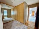 Spacious hallway with wooden flooring and large mirror wardrobe