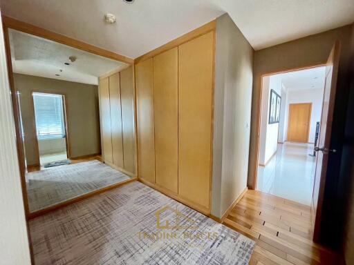 Spacious hallway with wooden flooring and large mirror wardrobe