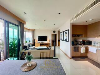 Modern open-plan living area with dining space, kitchen, and TV area