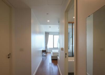 A hallway leading to a bedroom with a window