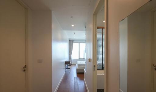 A hallway leading to a bedroom with a window