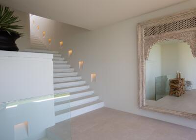 Modern staircase with decorative mirror and plant