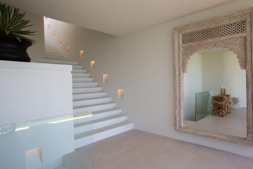 Modern staircase with decorative mirror and plant