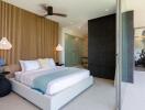 Modern bedroom with large bed, decorative elements, and access to balcony