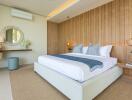 Modern well-lit bedroom with a large bed and decorative wooden wall