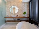 Modern bathroom with stone accent wall and round mirror