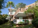 Modern multi-story building with large balconies and lush greenery