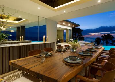 Luxurious dining area with a large wooden table and pool view