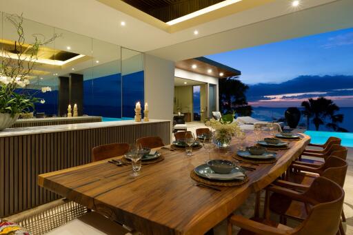 Luxurious dining area with a large wooden table and pool view