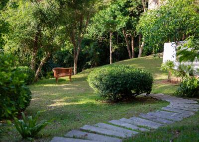 Lush garden with a wooden bench and stone pathway