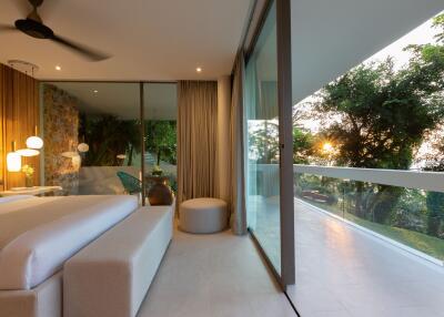 Modern bedroom with large glass windows and outdoor view