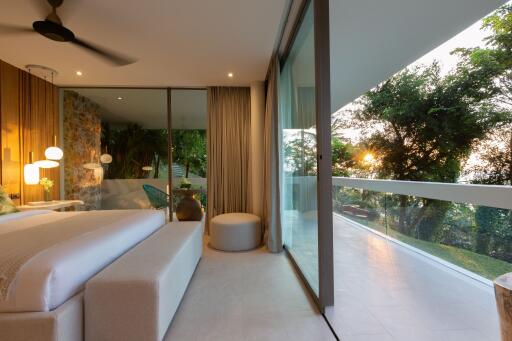 Modern bedroom with large glass windows and outdoor view