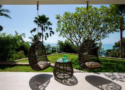 Outdoor patio with hanging chairs and ocean view