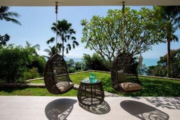 Outdoor patio with hanging chairs and ocean view