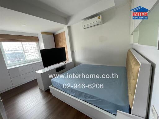 Bedroom with bed, TV, and air conditioner