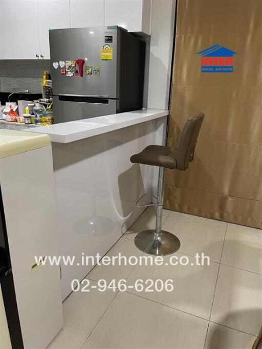 Modern kitchen with a counter, bar stool, and refrigerator