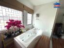 Bathroom with bathtub and potted plants by windows