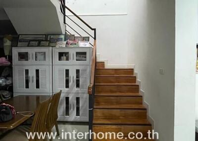 Staircase near dining area with storage cabinets