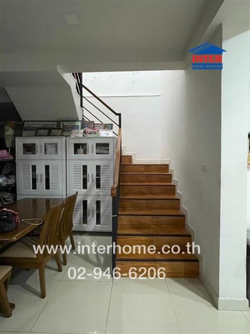 Staircase near dining area with storage cabinets