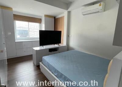 Modern bedroom with large window, air conditioning, and wooden floor