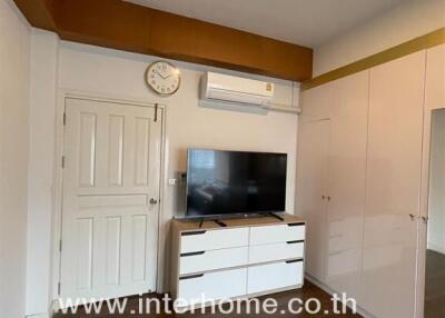 Bedroom with TV, air conditioning, wardrobe, and wooden floor