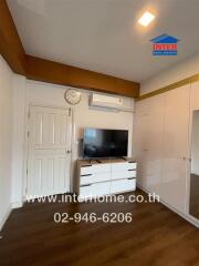 Bedroom with TV, air conditioning, wardrobe, and wooden floor