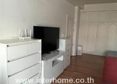 Living room with air conditioner, TV, and white furnishings