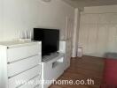 Living room with air conditioner, TV, and white furnishings