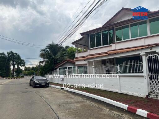 Two-story house with a gated front yard and a car parked on the street.