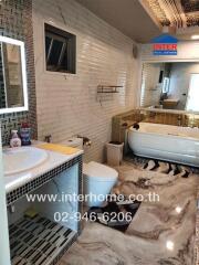 Modern bathroom with bathtub, sink, and decorative tiles