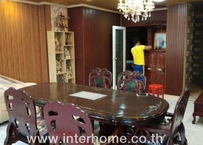 Dining area with wooden table and chairs, chandelier, and decorative elements in a living space