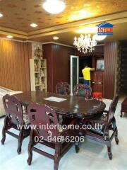 Dining area with wooden table and chairs, chandelier, and decorative elements in a living space