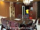 Dining area with wooden table and chairs, chandelier, and decorative elements in a living space