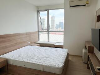 Bedroom with large window and city view