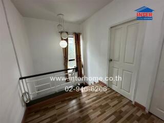 Hallway with wooden floor and white walls